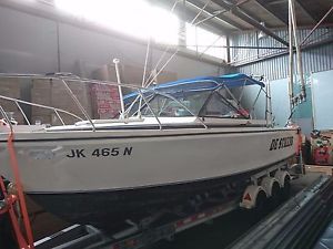 25 foot Bertram open runabout with aluminium tri axle trailer